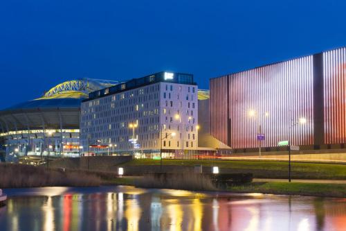 een gebouw naast een rivier in de nacht bij Jaz in the City Amsterdam in Amsterdam