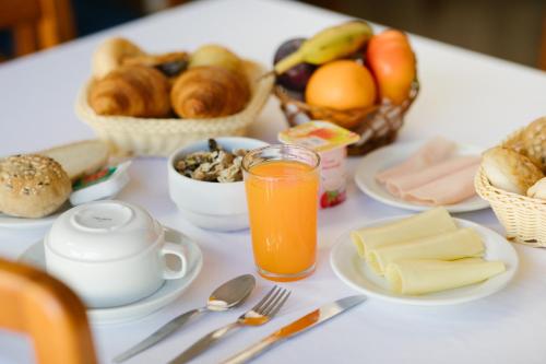 una mesa con desayuno y un vaso de zumo de naranja en Hotel Anjos, en Lisboa