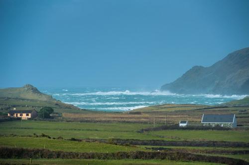 uma casa num campo com o oceano ao fundo em Atlantic Sunset em Portmagee