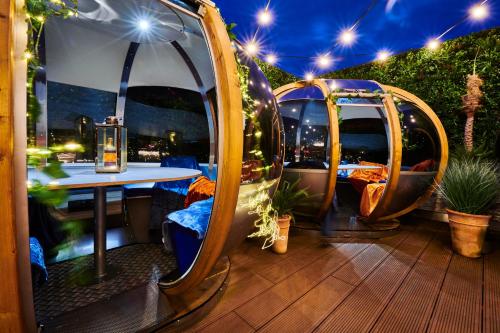 een patio met een tafel, stoelen en verlichting bij Genting Hotel & Spa at Resorts World Birmingham in Bickenhill