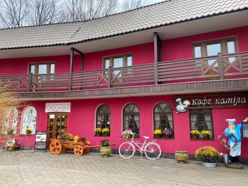 een roze gebouw met een fiets voor het gebouw bij Готель-ресторан Каміла in Polyana