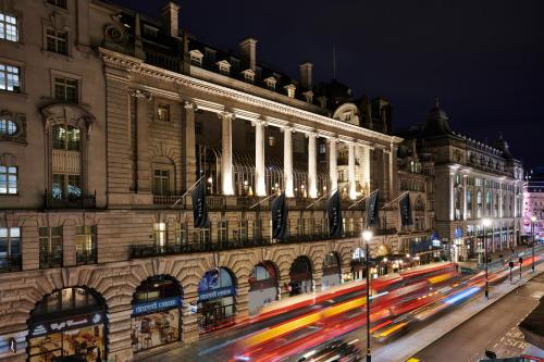 a building with streaks of traffic in front of it at night at The Dilly in London