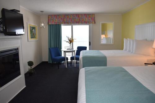 ein Hotelzimmer mit 2 Betten und einem TV in der Unterkunft Breakers Resort - Lakeside in Saint Ignace