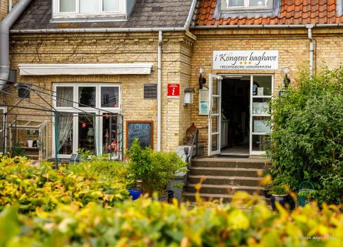 ein Backsteinhaus mit dem Haupteingang zu einem Geschäft in der Unterkunft Fredensborg Vandrerhjem, i Kongens baghave in Fredensborg