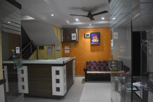 a living room with a kitchen and a couch at Hotel Sai Vishwa in Shirdi