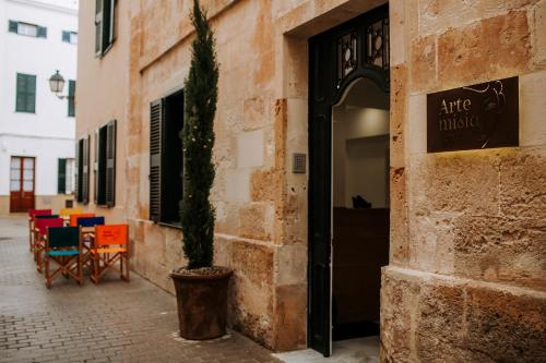 een plant in een pot naast een gebouw bij Hotel Artemisia in Ciutadella