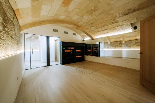 een grote kamer met een houten vloer en een plafond bij Hotel Artemisia in Ciutadella