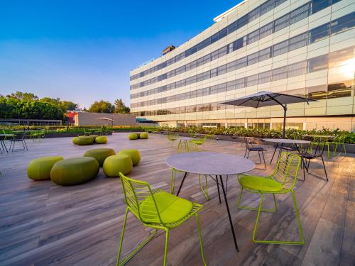 a patio with tables and chairs and a building at Galeria Plaza San Jeronimo in Mexico City