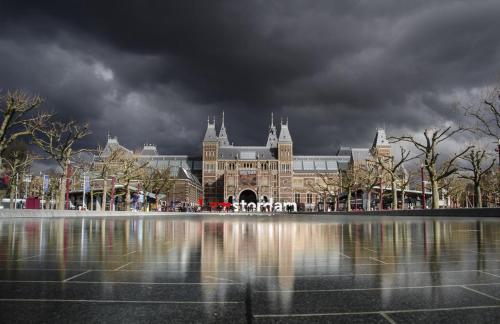 a large building with a reflection in a body of water at Boutique Studio Magielsen in Amsterdam