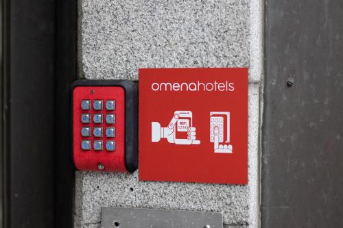 un panneau rouge sur un mur avec un téléphone portable dans l'établissement Omena Hotel Pori, à Pori