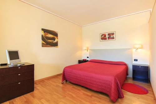 a bedroom with a red bed and a television at Hotel Residence La Luna Nel Porto in Stresa