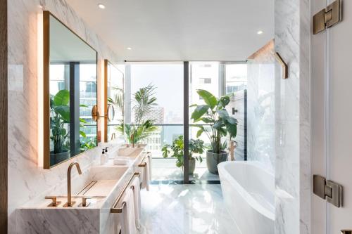 a bathroom with two sinks and a large window at The Hari Hong Kong in Hong Kong