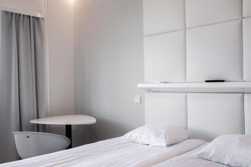 um quarto com uma cama, uma mesa e uma cadeira em Omena Hotel Turku Kauppiaskatu em Turku