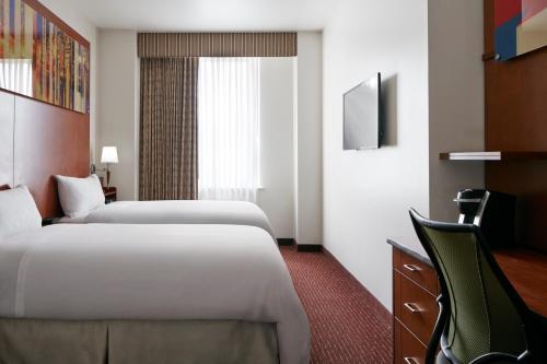 a hotel room with two beds and a desk at Club Quarters Hotel Rittenhouse Square, Philadelphia in Philadelphia