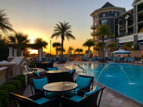 uma piscina com mesas e cadeiras ao lado de um hotel em Henderson Beach Resort em Destin