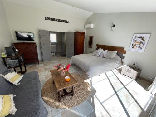 Sala de estar con cama y mesa en Gîte La maison dans l'Olivette, en Oraison