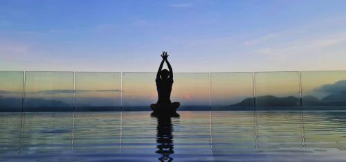 une personne faisant une pose de yoga dans l'eau dans l'établissement La Vague Hotel, à Nha Trang