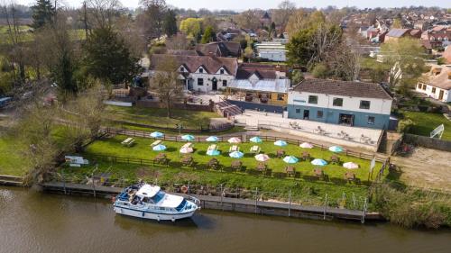 Una barca in acqua accanto a una casa di The Fleet Inn a Tewkesbury