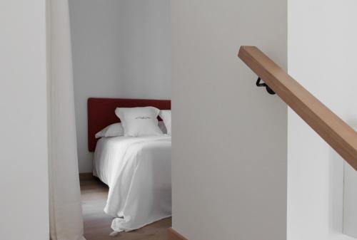 a bedroom with a white bed and a staircase at La Ermita Suites - Único Hotel Monumento de Córdoba in Córdoba