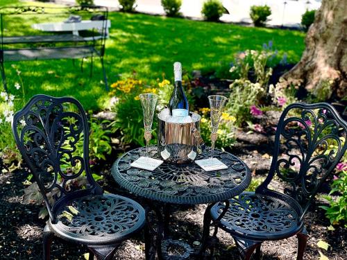 een tafel met een fles wijn en twee stoelen bij Buttonwood Boutique Hotel in West Cape May