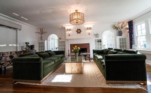 een woonkamer met groene banken en een tafel bij Buttonwood Boutique Hotel in West Cape May