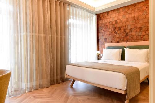 a bedroom with a bed with a brick wall at My Story Hotel Tejo in Lisbon