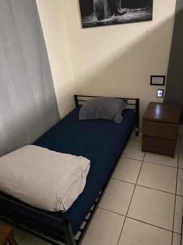 Schlafzimmer mit einem Bett mit blauer Matratze und einem Tisch in der Unterkunft Private Cubicle - Single Bed - Mixed Shared Dorm - MIAMI AIRPORT in Miami