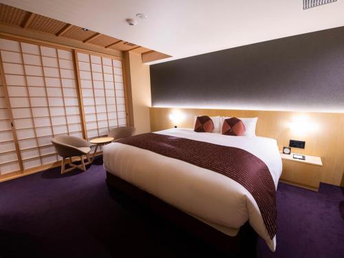 Un pat sau paturi într-o cameră la Homm Stay Nagi Shijo Kyoto By Banyan Group