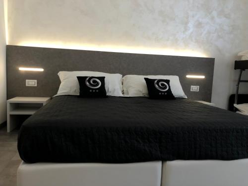 a bedroom with a large bed with black and white pillows at Sesto Senso Home in Santa Maria del Cedro