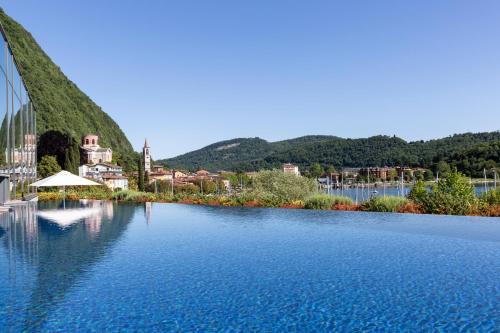 a large body of water with a town in the background at Hotel de Charme Laveno in Laveno-Mombello