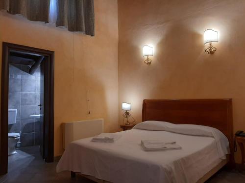 a bedroom with a bed and a bathroom with a toilet at Palazzo Marzano in Briatico