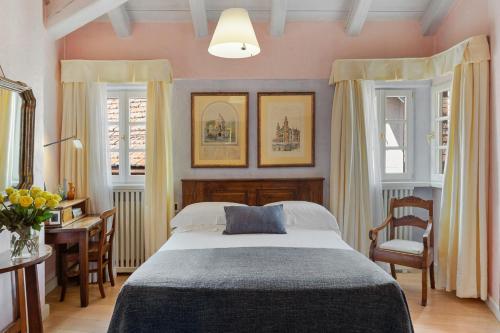 a bedroom with a bed and a table and chairs at Hotel Pironi in Cannobio