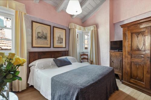 a bedroom with a bed in a room with pink walls at Hotel Pironi in Cannobio