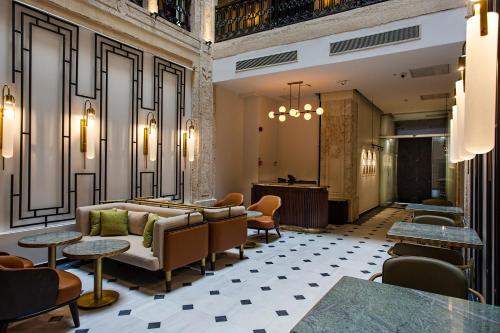 eine Lobby mit einem Sofa, Stühlen und Tischen in der Unterkunft Mest Hotel Istanbul Sirkeci in Istanbul