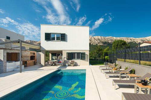 une villa avec une piscine et une maison dans l'établissement Villa Aurora, à Baška