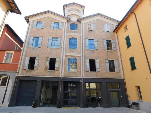 een oud bakstenen gebouw met een klok bovenop bij Piumaviola Beds & Apartments in Parma