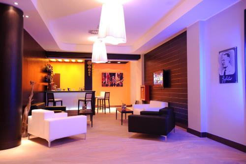 a living room with white chairs and a table at Hotel Guglielmo in Catanzaro