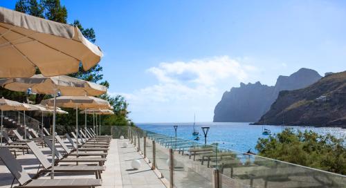 - une rangée de chaises de plage avec parasols et vue sur l'océan dans l'établissement Grupotel Molins, à Cala Sant Vicenç