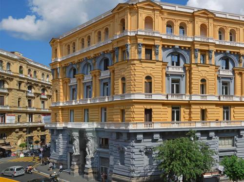 een groot geel gebouw voor een straat bij The One Napoli Luxury Apartment in Napels