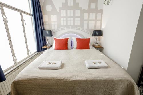 a bedroom with a large bed with two towels on it at Aris Amsterdam in Amsterdam