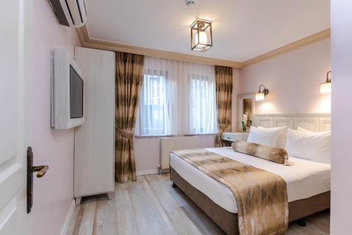 una camera con letto e televisore di Agora Guesthouse a Istanbul