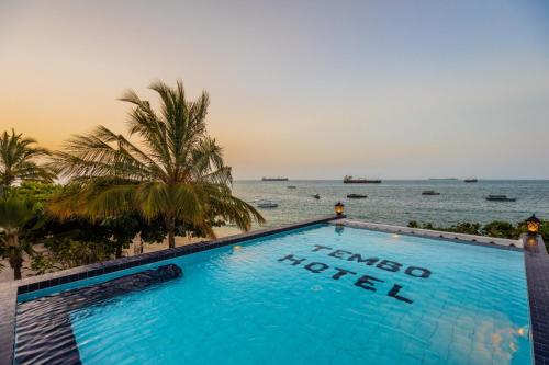 een zwembad met uitzicht op de oceaan in karma hotel bij Tembo House Hotel in Zanzibar City