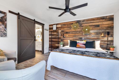 a bedroom with a bed and a wooden wall at Red Rock Inn Cottages in Springdale