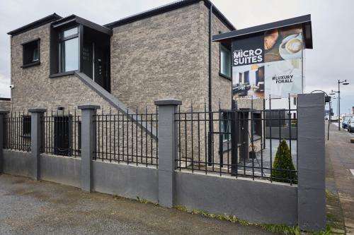 a building with a fence in front of it at Keflavik Micro Suites in Keflavík