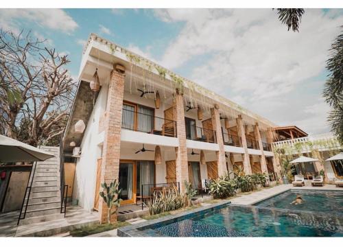 a hotel with a swimming pool in front of a building at Abdi Hotel in Gili Trawangan