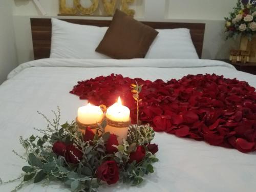 - un lit avec deux bougies et un cœur de roses dans l'établissement Hotel Làng Kò Hơ, à Đà Lạt