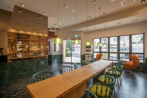 a restaurant with a large wooden table and chairs at the Moto Hotel Asakusa in Tokyo