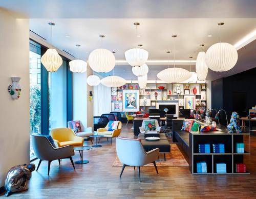 a living room with chairs and tables and chandeliers at citizenM San Francisco Union Square in San Francisco