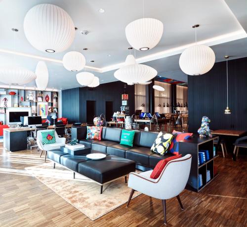 a living room with a couch and chairs and chandeliers at citizenM San Francisco Union Square in San Francisco