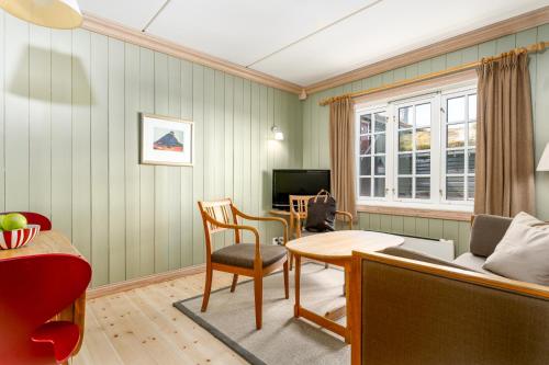 a living room with a table and a chair at Ilsetra Hotell in Hafjell